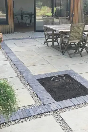 Charcoal Grey Brick Pavers laid as soldier courses to define areas within porcelain paving. Design by Anna Helps Garden Design.