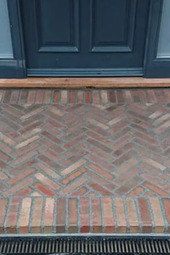 Bexhill Clay Pavers and mortar laid in herringbone pattern with soldier course borders on wide front door step by Plant Trap.
