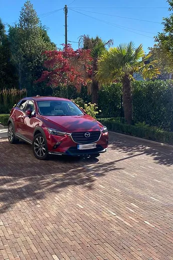 Red Mazda on front drive paved with Bexhill Clay Pavers. Gate and hedge form boundary with pavement. Design by Robert Hughes.